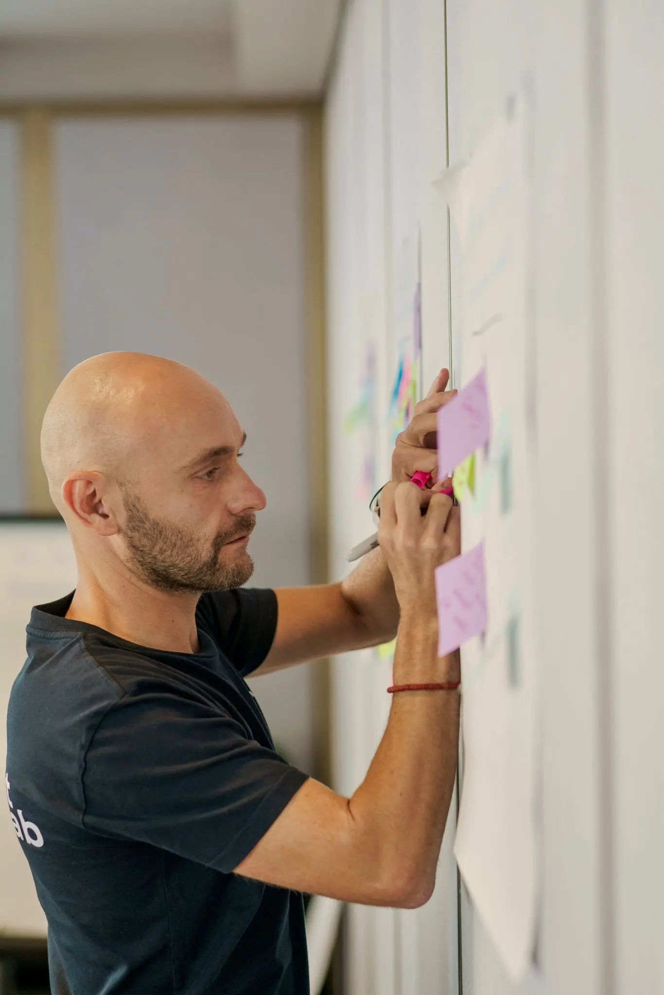 Steve Morris placing notes on a whiteboard during a leadership workshop
